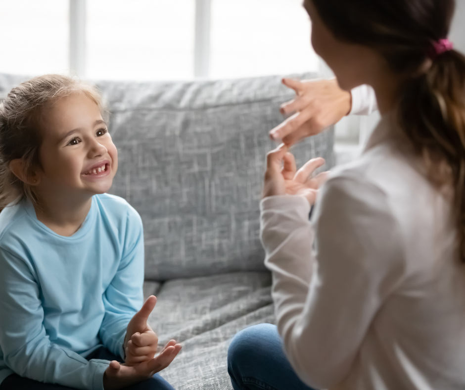 Nauczyciel rozmawiający z dzieckiem w języku migowy